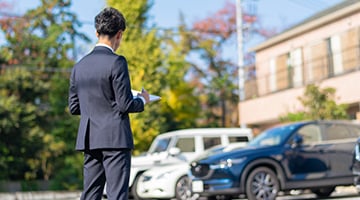 人が駐車場の査定をしている様子